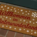 Weihnachtliche Fußmatte bemalen mit Schneeflocken und rotem Schriftzug
