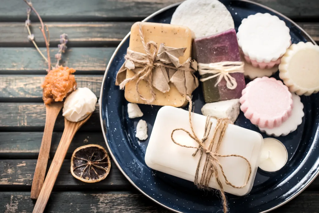 Handgemachte Seifen und Badezusätze auf Teller als kreative Wichtelgeschenke