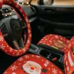 Innenraum mit Weihnachtsdeko fürs Auto – rote Sitzbezüge und Lenkrad mit Schneeflockenmotiv