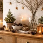 Winterdeko für die Kommode mit Naturmaterialien, Kerzen, Zweigen, Zapfen und wintergrünen Pflanzen in warmem Licht