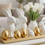 Weiße Keramikhasen und goldene Ostereier als stilvolle Osterdeko fürs Wohnzimmer auf goldenem Tablett
