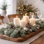 Winterdeko für den Esstisch mit Kerzen, Tannenzweigen und Zapfen in warmem Licht