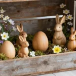 Osterdeko aus Holz in Holzkiste mit Holzhasen, Holzeiern, Moos und Frühlingsblumen in natürlicher Gestaltung