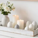 Helles Sideboard mit Tablett, Kerzen, Blumen und Eiern als schlichte März Deko für das Sideboard