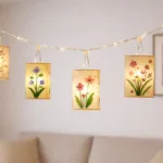 Hängende Papierlaternen mit Blumenmotiven und Lichterkette als stimmungsvolle Frühlingsdeko im Wohnzimmer.