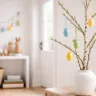 Osterdeko für den Flur mit Zweigen, Vase und bunten Ostereiern in hellem Eingangsbereich