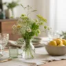 Esstisch Deko im Mai mit Wiesenblumen, Holz, Leinen und natürlichem Licht in ruhiger Atmosphäre