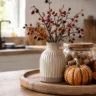 Herbstdeko für die Küche mit Kürbis, Hagebutten, Walnüssen und Leinentuch auf einem Holztablett.