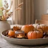 Herbstdeko für den Esstisch mit Kürbissen, Kerze, Naturmaterialien und Trockenblumen.