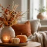 Herbstdeko für ein kleines Wohnzimmer mit Vase, Kürbissen, Kerze und warmen Naturfarben.