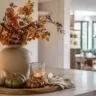 Herbstdeko für die offene Küche mit Vase, Kürbissen und Kerze auf der Kücheninsel.