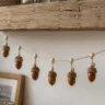 Herbstdeko mit Eicheln basteln: Eichelgirlande aus Naturmaterialien unter einem rustikalen Holzregal.