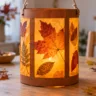 Herbstlaterne basteln mit Kindern: leuchtende DIY-Laterne aus Transparentpapier und Herbstblättern auf Holztisch.
