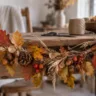 Herbstliche Girlande aus Naturmaterialien mit Blättern, Eicheln und Zapfen auf einem Holztisch.