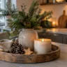Winterdeko für die Küche mit Kerze, Tannenzweigen, Holztablett und natürlichen Materialien auf der Kücheninsel.
