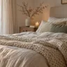 Winterdeko fürs Schlafzimmer mit hellem Bett, Strickdecke, Naturtönen und winterlichem Blick aus dem Fenster.