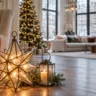 Großer leuchtender Weihnachtsstern und Laterne neben einem Sessel in einem weitläufigen Wohnzimmer.