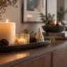 Dunkles Holz-Sideboard mit dekorativem Tablett, Kerzen, Tannengrün, Zapfen und kleinem Keramikbaum.