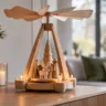Moderne Weihnachtspyramide aus hellem Holz mit Kerzen und Figuren auf einem Sideboard im Wohnzimmer.