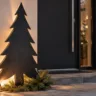 Moderne Weihnachtsdeko am Hauseingang mit großer schwarzer Tannenbaum-Silhouette aus Metall und warmer Beleuchtung.