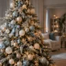 Eleganter Weihnachtsbaum mit eisblauen, weißen und champagnergoldenen Kugeln in einem hellen Wohnzimmer.