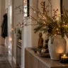 Weihnachtsdeko für den Flur mit Tannenzweigen, warmen Lichtern, Naturmaterialien und gemütlichen Dekorationen.