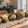 Moderne Weihnachtsdeko auf dem Esstisch mit Tannengrün, Eukalyptus, Kerzen und Weihnachtskugeln auf einem Leinenläufer.