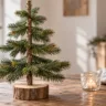 DIY-Weihnachtsbaum aus Tannenzweigen als einfache Weihnachtsdeko auf einem Holztisch.